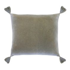 a grey pillow with tassels on it