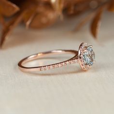 This modern and dainty engagement ring features a perfectly clear aquamarine center gemstone. Aquamarine is the birthstone for the March and would make a unique personalized engagement ring. The aquamarine has a lot of sparkle and has the slightest tint of blue-green color. It is really stunning in sunlight. A ring in this dainty style will look great on small hands or hands with slender fingers. The halo of diamonds makes the aquamarine look larger. This is a custom made to order ring. Please a Aquamarine Engagement Ring Vintage, Jewelry Rings Unique, Rings Pandora, Rose Gold Promise Ring, Pink Morganite Engagement Ring, Dainty Engagement Rings, Vintage Jewellery Rings, Wedding Rings Halo, Diamond Halo Ring