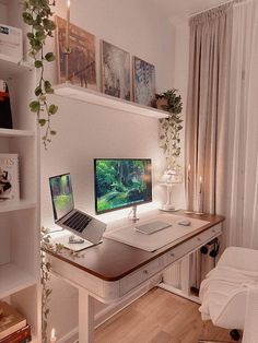 a desk with two computers on it in front of a window and bookshelf