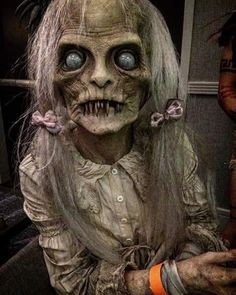 a creepy doll with long hair and blue eyes