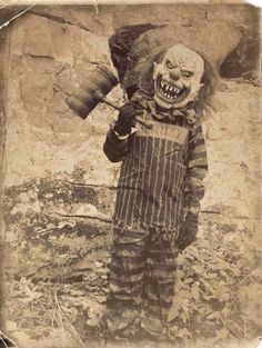 an old photo of a creepy clown holding something in one hand and looking at the camera