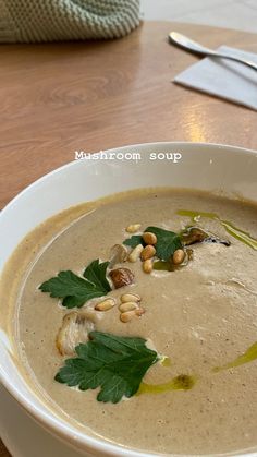 a white bowl filled with soup on top of a wooden table