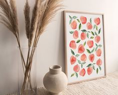 two vases are sitting on a table next to an art print with peaches