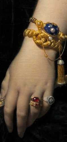 a close up of a person's hand with jewelry on it