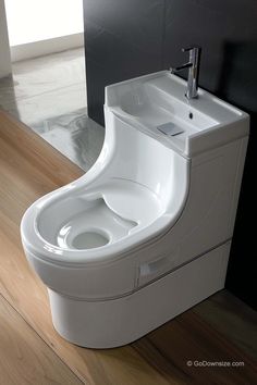 a white toilet sitting on top of a wooden floor