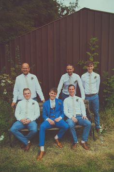 a group of men sitting on top of a wooden bench