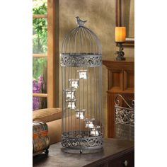 a metal bird cage with candles in it