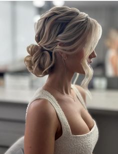 a woman with blonde hair wearing a white dress and braid in her hair, looking off to the side