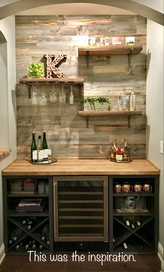 a wine rack with bottles and glasses on it next to a wall that has wood planks