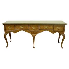 an antique wooden desk with two drawers on one side and a marble top on the other