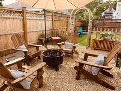 an outdoor patio with wooden chairs and umbrella