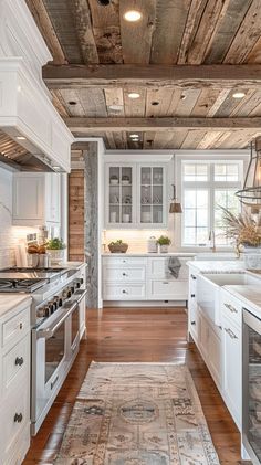 a large kitchen with white cabinets and wood flooring on the ceiling, along with an area rug