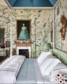 a bedroom decorated in blue and white with a painting on the wall above the bed