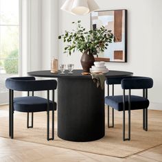 a dining room table with blue chairs and a potted plant