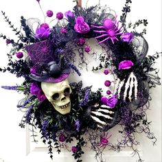 a wreath decorated with purple flowers and skulls