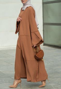 Introducing the Deluna three piece maxi lightweight abaya in rustic brown. This elegant and versatile design is perfect for any season and includes a long sleeve slip dress, apron piece, and a throw over abaya. The fabric is specially designed to resist wrinkles and the contrast brown color overlook seam at the edge of the abaya stands out.The abaya is super lightweight and flowy making it perfect for hot weather. The apron piece allows you to adjust the fit and the pattern of the abaya is not o Modest Long Abaya For Fall, Solid Color Long Maxi Dress For Eid, Modest Maxi Length Abaya For Fall, Long Modest Abaya With Dabka, Fall Season Modest Maxi Length Abaya, Bohemian Long Sleeve Abaya For Fall, Fall Modest Maxi Length Abaya, Elegant Long Thobe For Fall, Elegant Brown Thobe For Eid