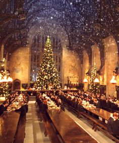 a large dining hall filled with people sitting at long tables and christmas trees in the background