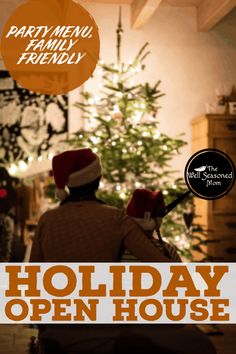 a man sitting in front of a christmas tree with the words holiday open house on it