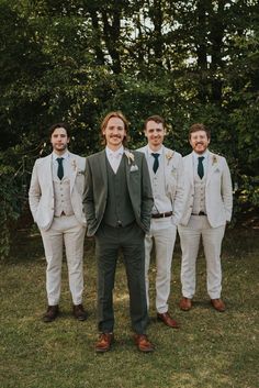 a group of men standing next to each other on top of a lush green field