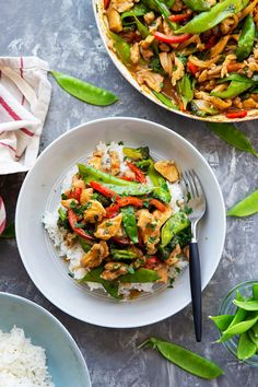 a white plate topped with rice and veggies next to a bowl of chicken