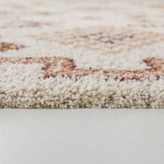 a white rug with brown and beige designs on the bottom half, in an area that looks like it could be used as a carpet