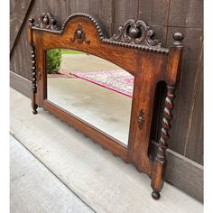 an old wooden mirror sitting on the side of a building