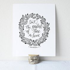 a card with the words, but the greatest of those is love on it next to a cup