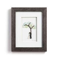 a framed art piece with a tree in it