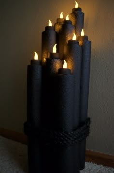 a bunch of lit candles sitting on top of a carpeted floor next to a wall