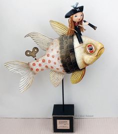 a figurine is sitting on top of a fish