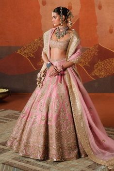 Pretty in gulab blush, the gulab barfi lehenga is intricately crafted with tropical motifs like sehra and amaltas. Finished with our berry bel motif border, it adds a whimsical touch that's iconic to a Masaba bride. Brought to life with age-old crafts like zardozi and sitara embroidery, it is paired with a heavily embellished blouse. The ensemble is further styled with an additional veil adorned with dainty embroidery work, making this look perfect for any bride. It also comes with a separate ca Pink Palazzo Set With Dori Work, Bollywood Style Pink Palazzo Set With Pallu, Pink Sharara For Navratri, Pink Palazzo Set For Diwali, Pink Anarkali Choli With Cutdana, Pink Raw Silk Palazzo Set For Reception, Traditional Pink Palazzo Set For Reception, Elegant Pink Palazzo Set With Cutdana Details, Elegant Pink Palazzo Set With Cutdana