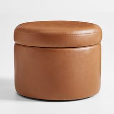 a brown leather ottoman sitting on top of a white floor