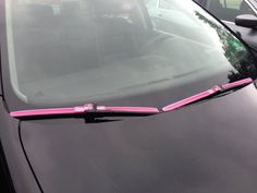 a black car with pink ribbon on the windshield