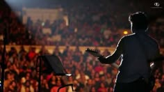 a man playing guitar in front of an audience