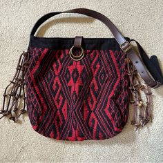 Jadetribe - Nicole Messenger Bag - Red & Black - Never Used But No Tag - 6 Brown Leather Tassels On Each Side. - Snap Closure - Adjustable Belt Strap With 5 Hole Selections - Inside Is Black, Includes One Pocket. - Made In Thailand. This Hand Woven Messenger Bag Is Created From Organic Cotton And Natural Dyes. - Has A Scratch On The Clasp. Seen In Photo But From A Distance It Is Faint. - Including 2 Stock Photos Of A Different Color. Approximately L15 X H15 X W3 Inches 36” - Strap On Shortest Se Bohemian Shoulder Bag With Detachable Strap For Travel, Red Handwoven Pouch Bag, Traditional Red Shoulder Bag For Everyday Use, Bohemian Red Rectangular Bucket Bag, Red Bohemian Rectangular Bucket Bag, Traditional Handwoven Black Bags, Traditional Black Handwoven Bags, Handmade Red Hobo Bag For Travel, Black Handwoven Hobo Bag For Everyday