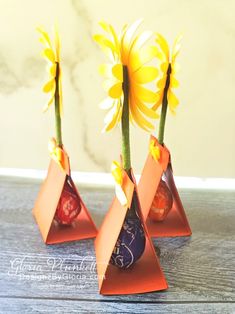 three vases with yellow flowers in them on a table