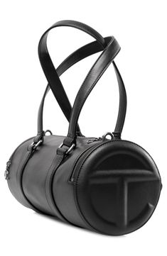 Designed by visionary Telfar Clemons, this medium duffle bag is crafted in signature faux leather, boasting embossed TC logo side pockets and a spacious interior with an inner pocket. Accented with custom antique silver hardware and logo zipper pulls, it’s finished with twin handles and a detachable shoulder strap—your perfect partner for style and function. Top zip closure Top carry handle; removable, adjustable crossbody strap Exterior zip pockets Interior zip pocket Structured silhouette Line Designer Leather Duffle Bag With Removable Pouch, Sporty Leather Crossbody Bag, Designer Leather Duffle Bag With Zipper Closure, Modern Leather Duffle Bag With Handles, Sporty Leather Shoulder Bag With Removable Pouch, Sporty Leather Shoulder Bag With Zipper Closure, Sporty Leather Duffle Bag, Sporty Leather Duffle Bag For On-the-go, Telfar Duffle Bag