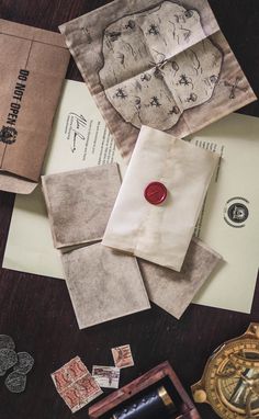 several old envelopes and stamps on a table with a wax seal, stamp pad, and ink pen