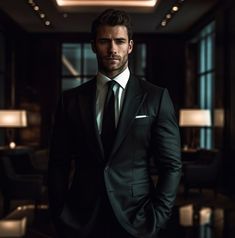 a man wearing a suit and tie standing in a room with lights on the ceiling