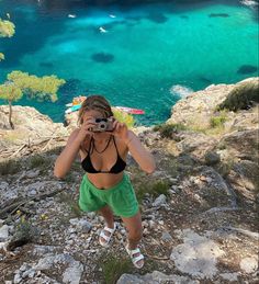 a woman taking a photo on top of a mountain