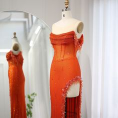 an orange dress on display in front of a mirror