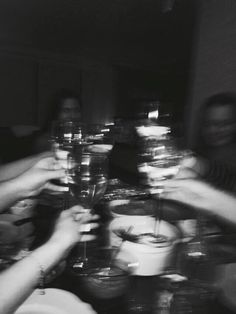 black and white photograph of people sitting at a table with wine glasses in their hands