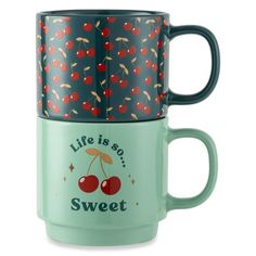 two mugs with cherries on them sitting next to each other, one has the words life is so sweet