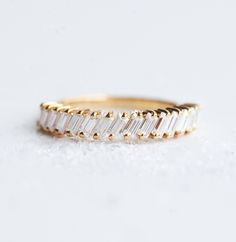 a gold ring with three baguettes on the side and two rows of diamonds