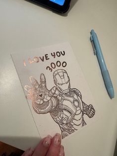 someone is holding up a card that says i love you 30000 with an iron man drawing on it