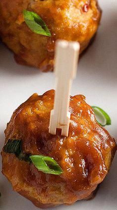 small appetizers with toothpicks in them sitting on a white plate and garnished with green leaves