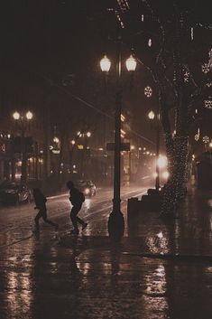 two people running in the rain at night