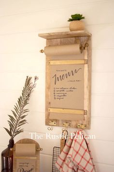 a sign hanging on the wall next to a potted plant and other items in front of it