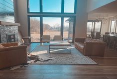 a living room filled with furniture and a fire place in front of a large window