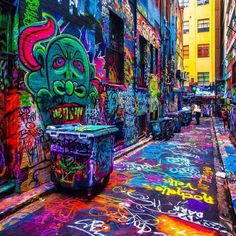 an alleyway with graffiti all over the walls and floors, painted in bright colors